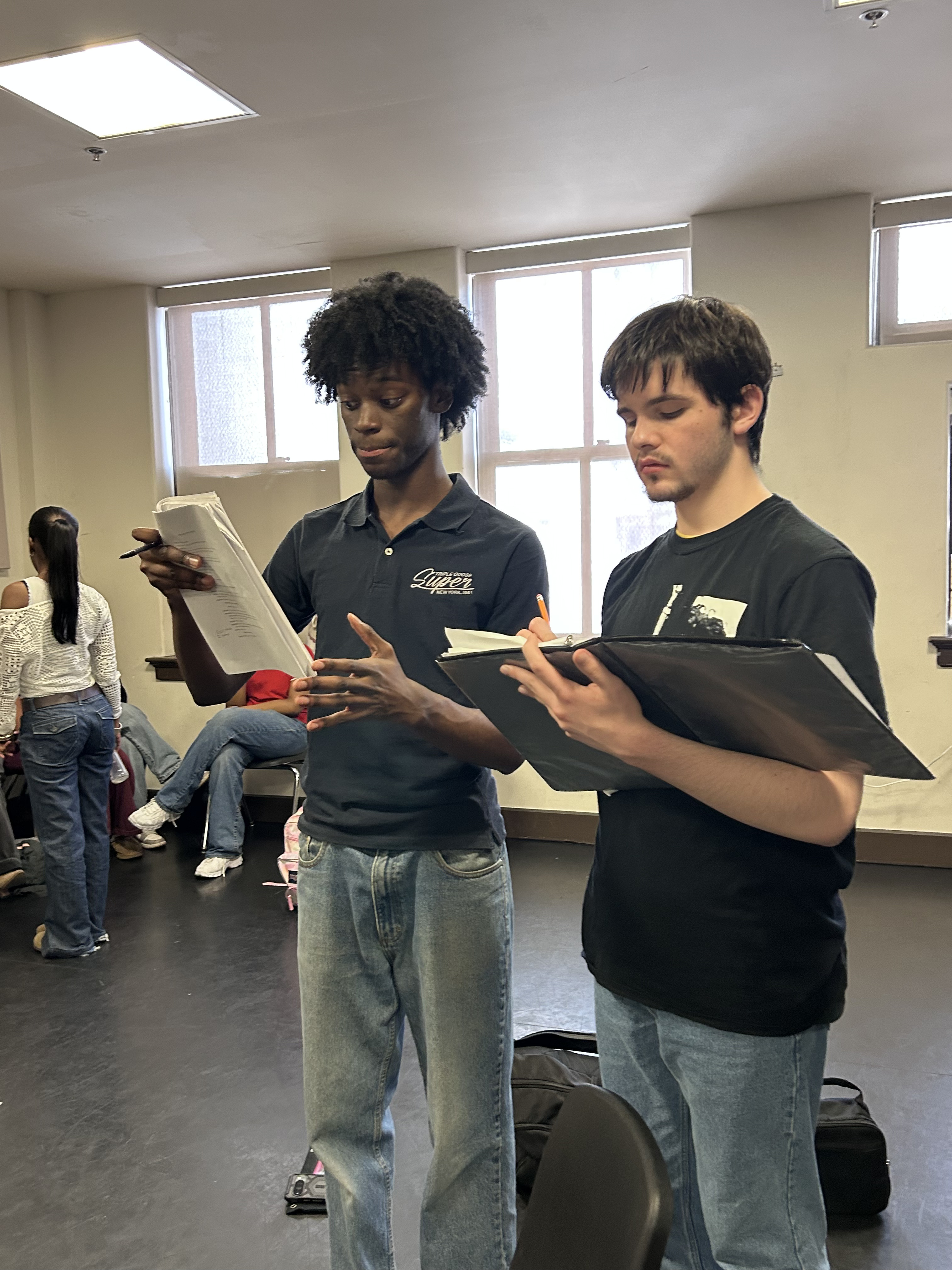 Two actors on stage reviewing blocking